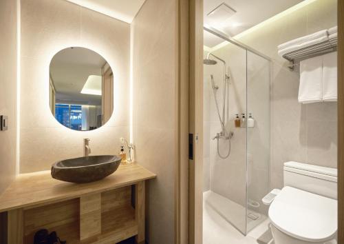 a bathroom with a sink and a toilet and a mirror at UH Suite Seoul Deoksugung in Seoul