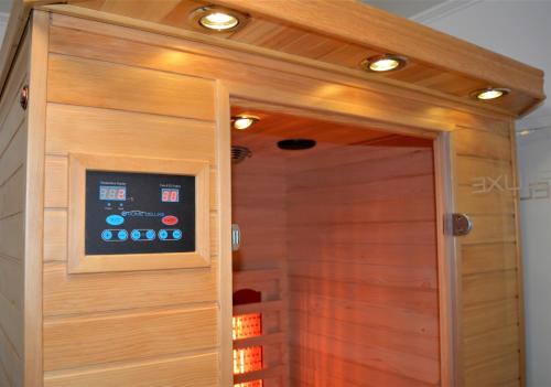 a shower with a wooden door with lights above it at Chalet Auszeit in Olsberg