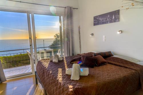 a bedroom with a bed with a view of the ocean at Sandy Coast Hospitality in Agios Gordios
