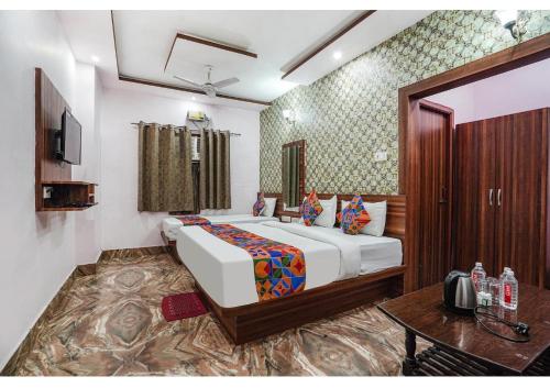 Un dormitorio con una cama grande y una mesa. en Ashiyana Hotel en Varanasi