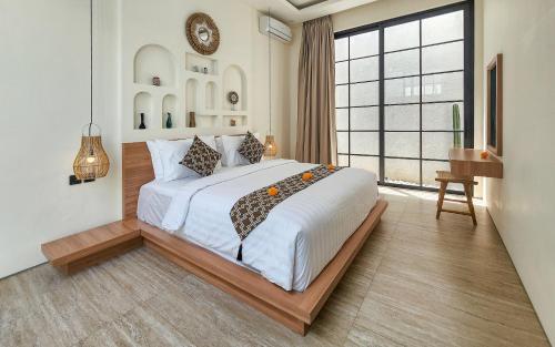 a bedroom with a large bed and a large window at Dandelion Villas Pandawa by Nagisa Bali in Badung