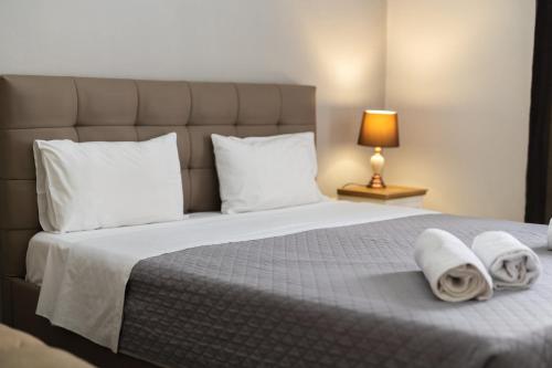 una camera da letto con un grande letto con asciugamani di HILI RESORT LUXURIOUS SEASIDE APARTMENT a Alexandroupoli