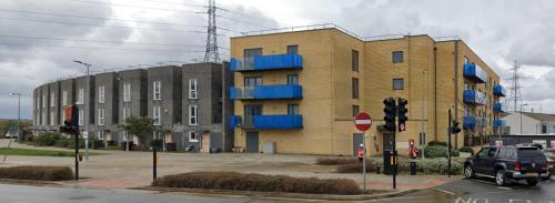 a building with blue balconies on the side of a street at Your ideal ExCel London- O2 Arena - LCY Airport homestay in Barking