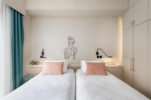 2 letti posti uno accanto all'altro in una camera da letto di Colors Hotel Athens ad Atene