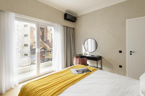 a bedroom with a bed and a large window at Colors Hotel Athens in Athens