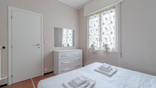 Habitación blanca con cama y espejo en Italianway - Firenze 11, en Rapallo