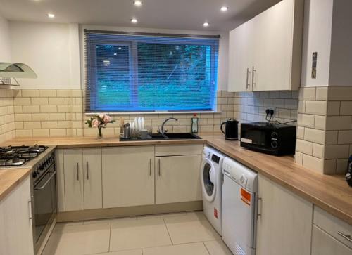 a kitchen with a sink and a washer and dryer at Short term let Room In DE1 in Derby