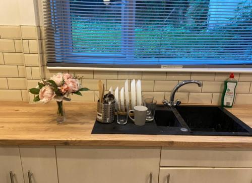 a kitchen counter with a sink and a vase of flowers at Short term let Room In DE1 in Derby