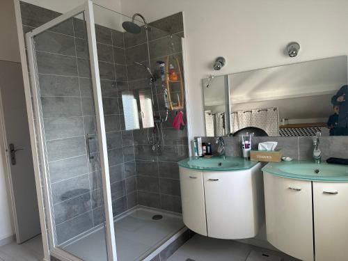 ein Bad mit 2 Waschbecken und einer Dusche in der Unterkunft Villa de charme, piscine privée et pool-house in Domarin