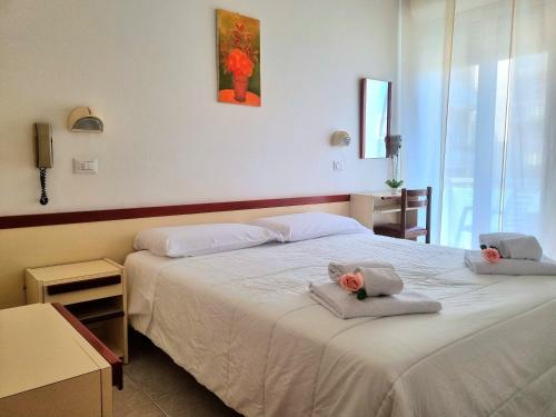 a bedroom with two beds with towels on them at Due Gemelle in Rimini