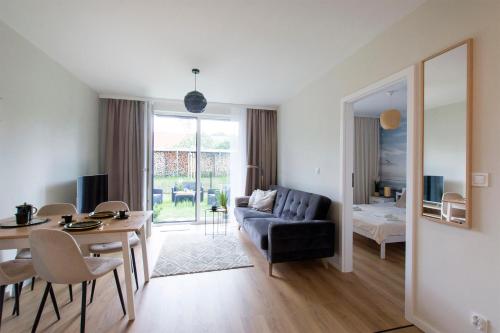 a living room with a couch and a dining room at Golden Sand - Baltic Line in Gdańsk