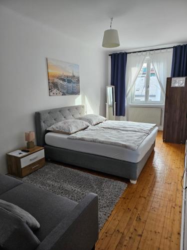 a bedroom with a bed and a couch and a window at Vienna Center,private zimmer, ! in Vienna