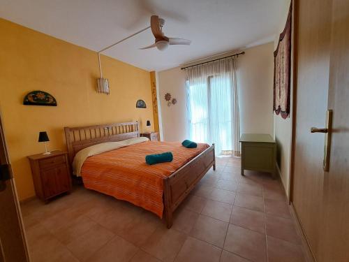 Un dormitorio con una cama y un ventilador de techo. en Casa Amarilla, en Es Pujols