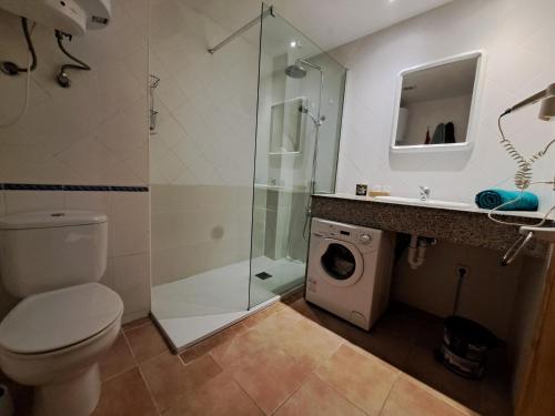 a bathroom with a shower and a washing machine at Casa Amarilla in Es Pujols