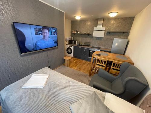 a room with a bed and a television on a wall at Rohuaia 22 Apartment in Rakvere