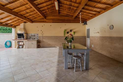 an open kitchen with a table and stools at Casa Maria - Paraíso Rural in Jesufrei