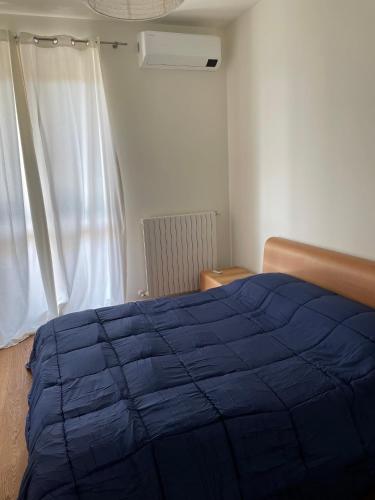 a bedroom with a blue bed and a window at Casa Laura in Bergamo