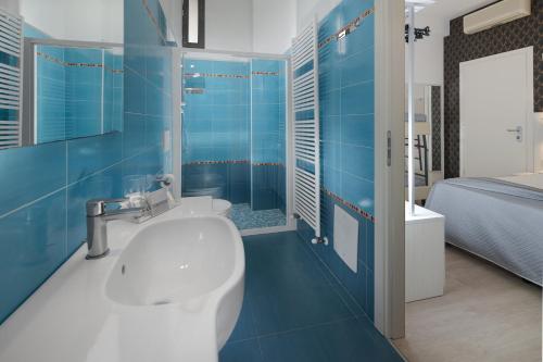 y baño azul con lavabo y ducha. en Hotel Eiffel en Rímini