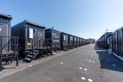 a row of train cars parked on the side of a road at HOTEL R9 The Yard Sakuragawa in Sakuragawa