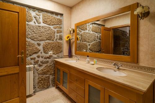 a bathroom with a sink and a mirror at Casa Maria - Paraíso Rural 