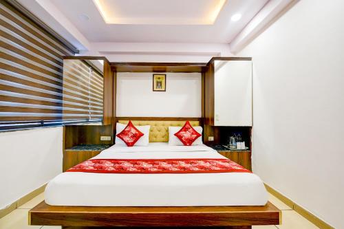 a bedroom with a large bed with red pillows at Hotel Le Grand - Walk-in from RK Ashram Metro Station in New Delhi