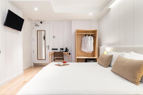 a bedroom with a large white bed and a chair at Casa Bella Gracia by Aspasios in Barcelona