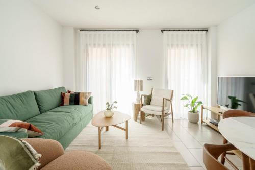 uma sala de estar com um sofá verde e uma mesa em Racons - La Placeta em Vic