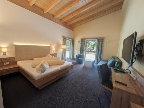 a large room with a bed and a television at Hotel Forelle in Plansee