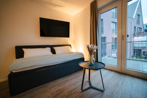 um quarto com uma cama, uma mesa e uma janela em ZENtrahome - Balkon Outlet Zentral SmartTV Business em Metzingen