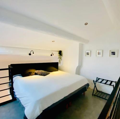 une chambre avec un grand lit blanc et une chaise dans l'établissement Duplex tout confort prox bd chave/ plaine, à Marseille