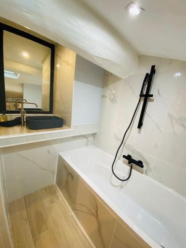 une salle de bain blanche avec un lavabo et un miroir dans l'établissement Duplex tout confort prox bd chave/ plaine, à Marseille
