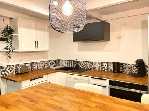 une cuisine avec une table et une lampe pendant dans l'établissement Duplex tout confort prox bd chave/ plaine, à Marseille