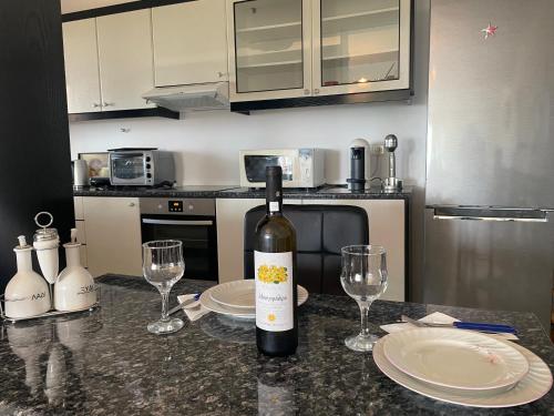 a bottle of wine sitting on a counter with two glasses at Eagles Nest Villa Athenian Riviera in Aghia Marina near Lagonisi, next to the beach close to Athens Airport in Aghia Marina