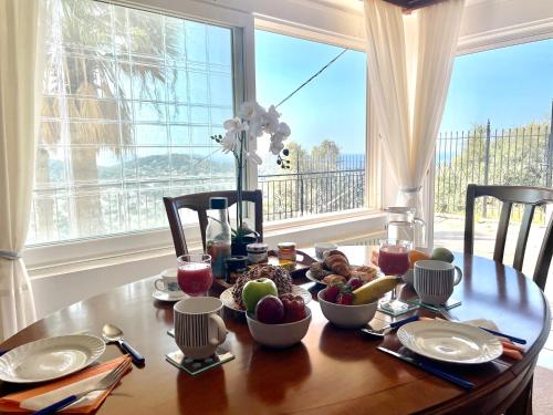 a wooden table with food on it with a window at Eagles Nest Villa Athenian Riviera in Aghia Marina near Lagonisi, next to the beach close to Athens Airport in Aghia Marina