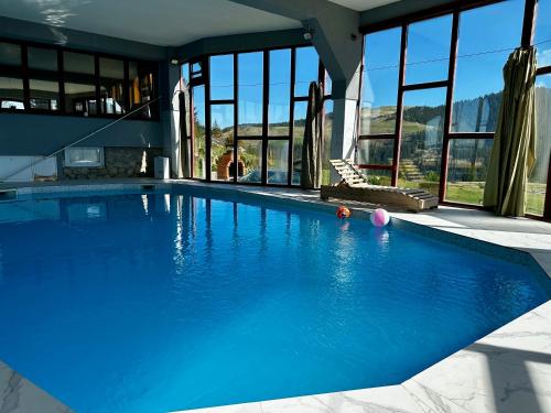 a swimming pool with blue water in a house at Vlasic Odmor - Villa Wellnes & spa in Vlasic