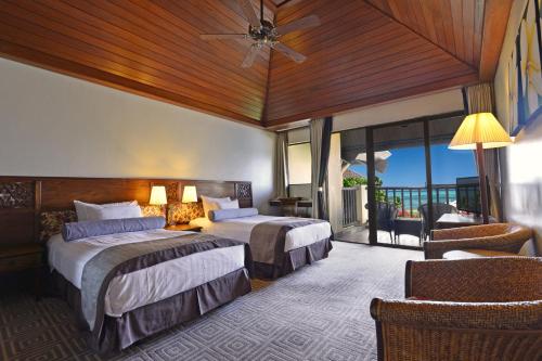 a hotel room with two beds and a balcony at Aqua Resort Club Saipan in Saipan