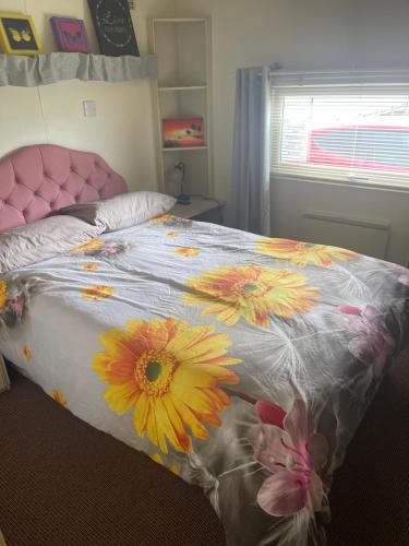 a bedroom with a bed with flowers on it at Caravan 2 coral beach Ingoldmells 6 berth in Ingoldmells
