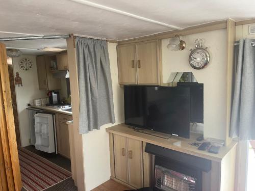 a living room with a television and a kitchen at Caravan 2 coral beach Ingoldmells 6 berth in Ingoldmells