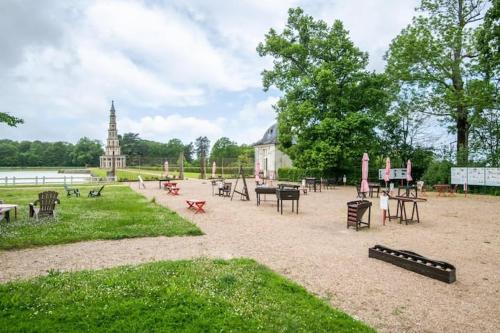 un parc avec des bancs et des tables et un bâtiment avec une église dans l'établissement The Chanteloup Pagoda, à Amboise