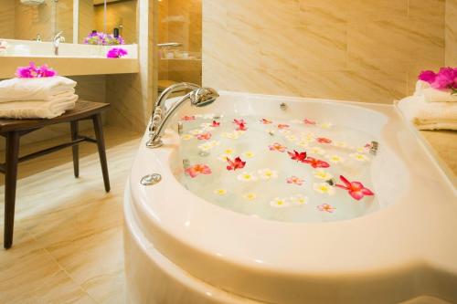 bañera con flores en el baño en Aqua Resort Club Saipan en Saipan