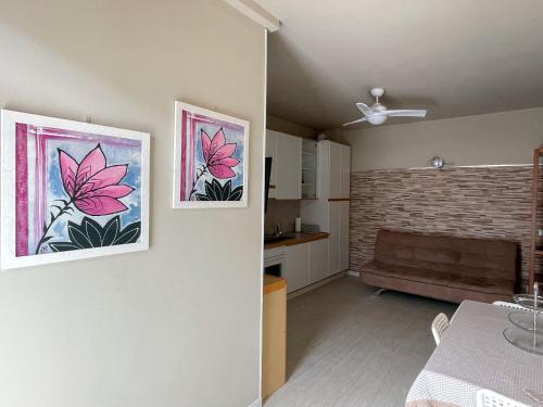 a living room with two pictures of flowers on the wall at Antonella's center town apartment Valbrona in Valbrona