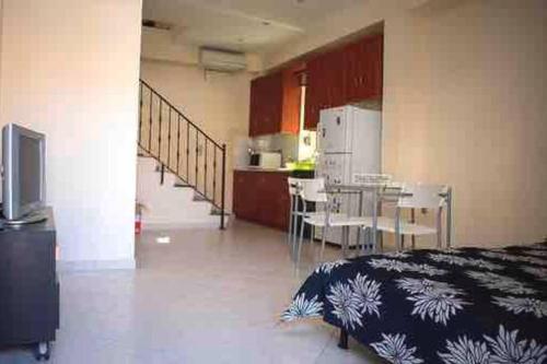 a room with a kitchen and a table and chairs at Traditional stone-built house with great view in Kondiás