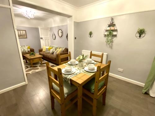 comedor y sala de estar con mesa y sillas en 4 Bedroom House near City Centre with Parking en Gloucester