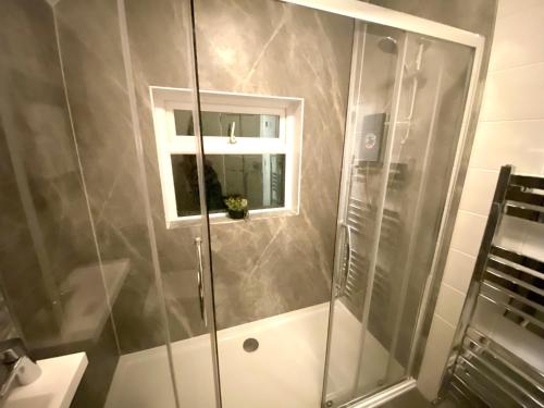 baño con ducha y ventana en 4 Bedroom House near City Centre with Parking, en Gloucester