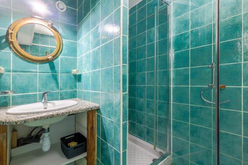 a blue tiled bathroom with a sink and a mirror at L'Isula - Appt pour 5 climatisé avec piscine in LʼÎle-Rousse