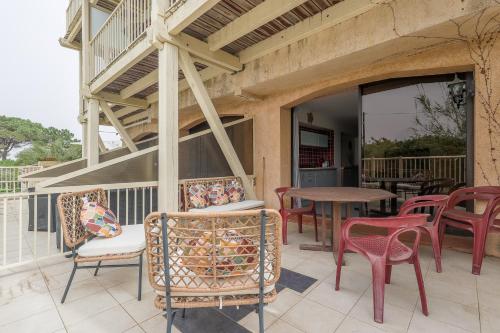 a patio with chairs and a table on a balcony at L'Isula - Appt pour 5 climatisé avec piscine in LʼÎle-Rousse