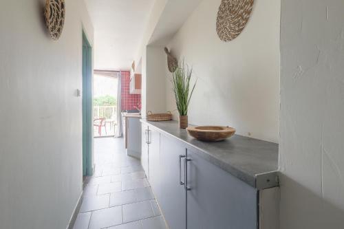 a kitchen with white cabinets and a counter top at L'Isula - Appt pour 5 climatisé avec piscine in LʼÎle-Rousse