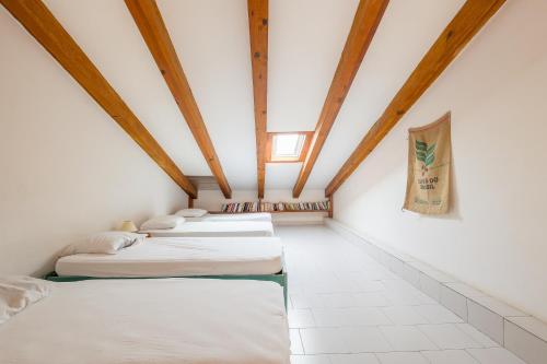 - une rangée de lits dans une chambre dotée de plafonds en bois dans l'établissement Le Rocher - Appt pour 6 climatisé avec piscine, à LʼÎle-Rousse