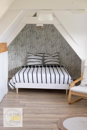 - un lit avec des oreillers à rayures noir et blanc dans une chambre dans l'établissement Le Petit Havre d'Esneval - proche d'Etretat -, à Criquetot-lʼEsneval