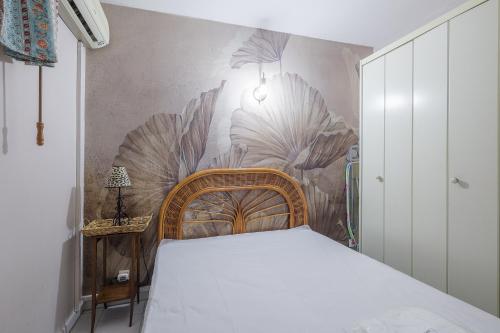 - une chambre avec un lit et une fresque murale de plantes dans l'établissement Le Petra Paoli - Appt climatisé avec piscine, à LʼÎle-Rousse